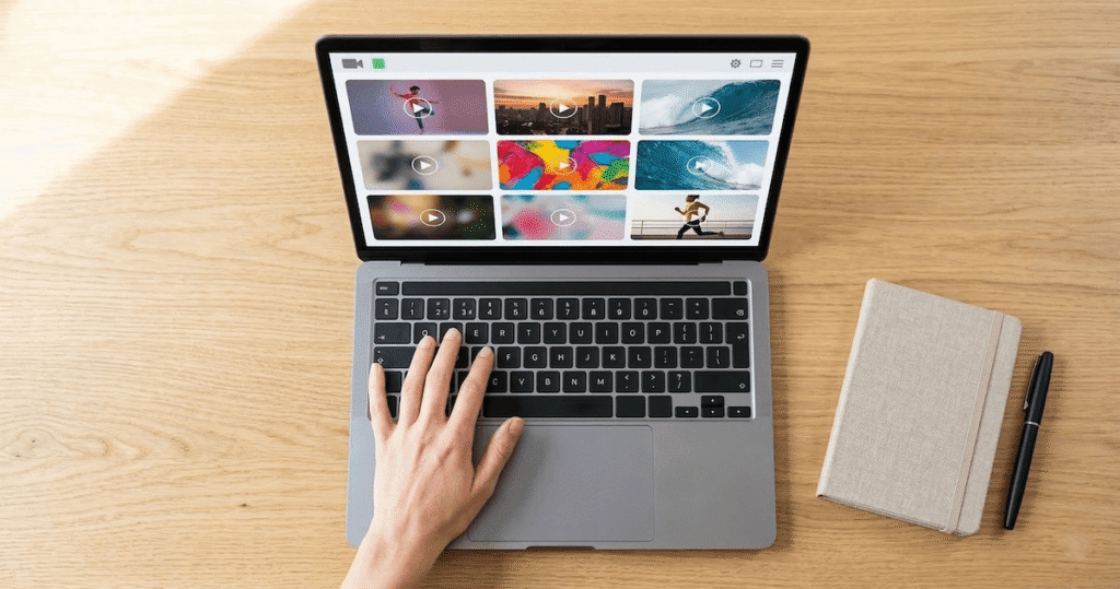 Top-down view of a laptop screen showing a grid of video ad  thumbnails on a video creation dashboard with Creatify AI