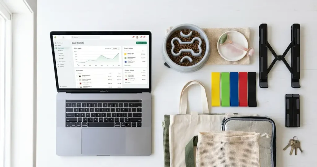 A selection of best dropshipping products in 2026 arranged next to an open laptop showing an online store